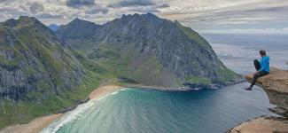 Traveler sitting at the edge of a rock formation (photo: stein egil liland/Pexels)